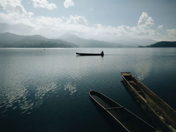 Boat in calm sea against mountain range