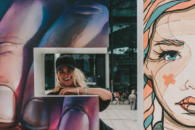 Portrait of smiling young woman with graffiti wall