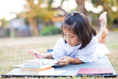 Side view of a young woman reading book