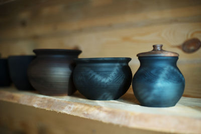 Close-up of pots on shelf at workshop
