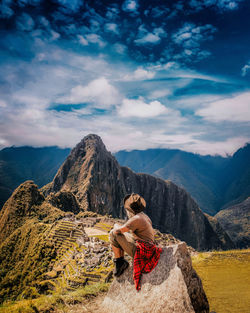 Rear view of woman looking at mountain against sky