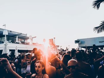 Group of people at music concert against sky