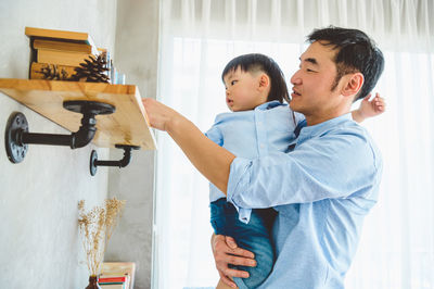 Father and son standing at home