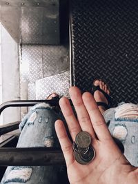 Low section of woman holding coins in bus