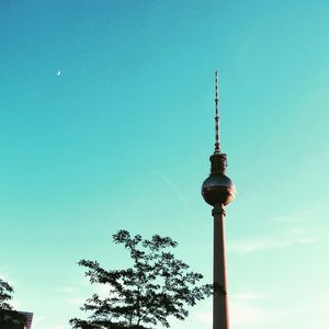 Low angle view of communications tower against blue sky