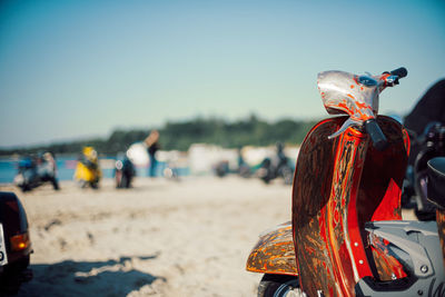 Part of old rusty scooter standing on the beach