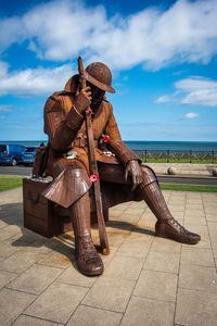 Rear view of man sitting on seat against sky