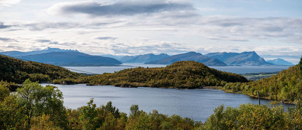 Scenic view of lake by mountains against sky