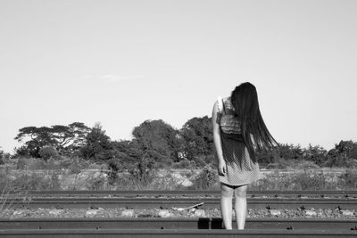 Rear view of woman standing against clear sky