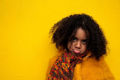 Portrait of sad girl on yellow background