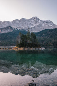 Scenic view of lake by snowcapped mountains against sky