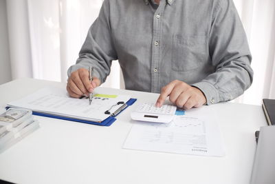 Midsection of man using laptop on table