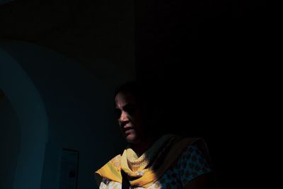 Portrait of young man against black background
