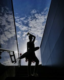 Low angle view of silhouette man standing against sky