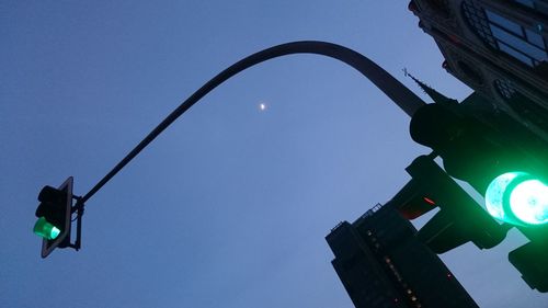 Low angle view of road sign against clear blue sky