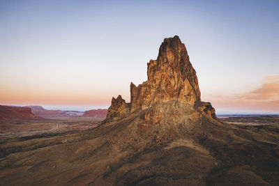 Rock formations on landscape against sky during sunset