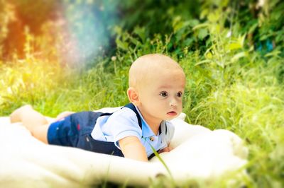 Portrait of cute boy lying on grass