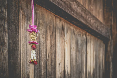 Close-up of christmas decoration hanging in front of wooden wall