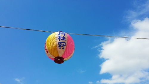 Low angle view of lantern against blue sky