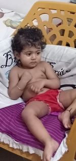 High angle view of baby relaxing on bed at home