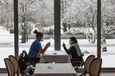 People sitting on table in park during winter