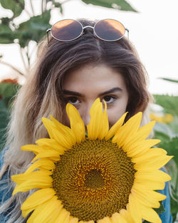 Close-up portrait of woman with sunflower