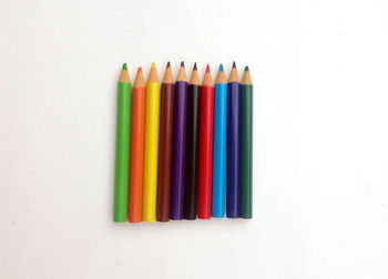 High angle view of colored pencils against white background