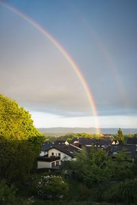 Scenic view of rainbow over buildings against sky