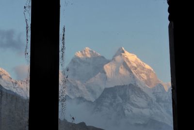 Close-up of snow covered mountains seen through window