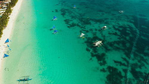 Lagoon with turquoise water, sailing yachts and white sand beach from above. boracay, philippines. 