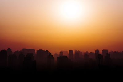 Silhouette buildings against sky during sunset