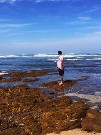 Full length of man standing on beach against sky