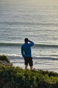 Rear view of man standing at beach
