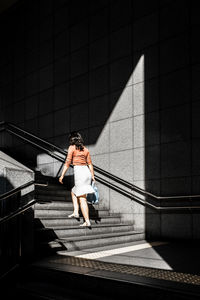 Rear view of woman walking on staircase