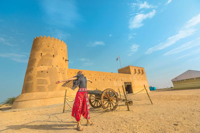 Woman standing against fort in city