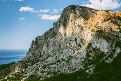 Low angle view of rocky mountains against sky