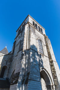 Low angle view of old building against clear blue sky