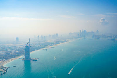 Aerial view of sea and buildings against sky