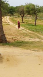 Rear view of woman standing on field