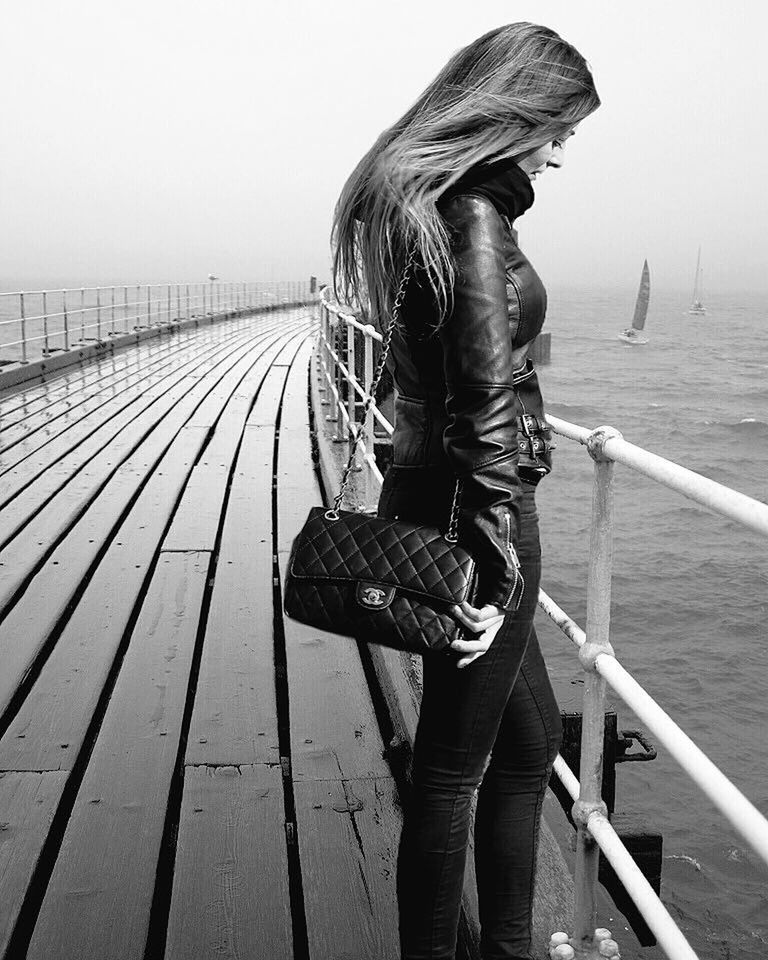 REAR VIEW OF WOMAN STANDING ON PIER