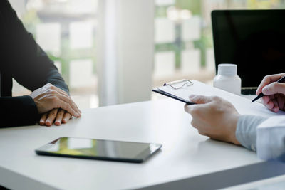 Midsection of man using laptop on table