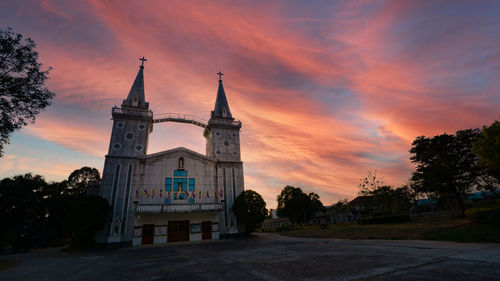 View of building against cloudy sky at sunset