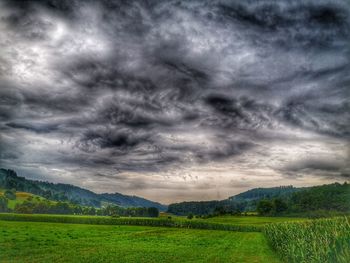 Scenic view of field against cloudy sky