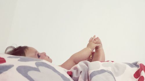 Baby boy lying against white background