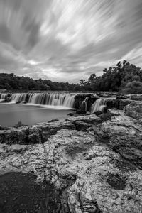 Scenic view of waterfall against sky