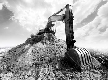 Abandoned machinery on field against sky