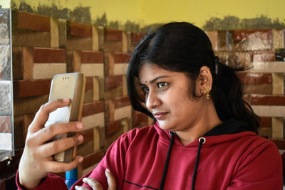 Portrait of mid adult man using mobile phone in restaurant