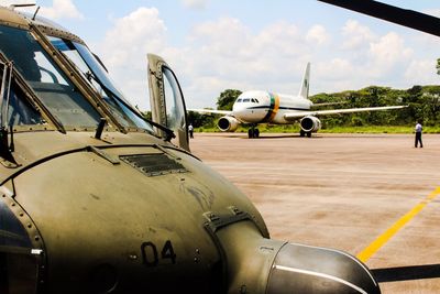 Close-up of airplane at airport runway against sky