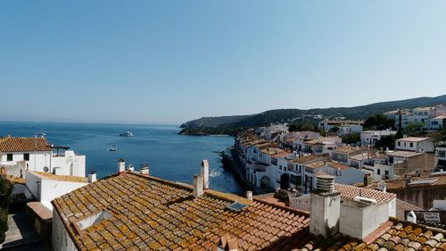 High angle view of townscape by sea against clear sky