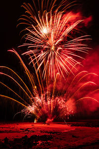 Firework display at beach during night